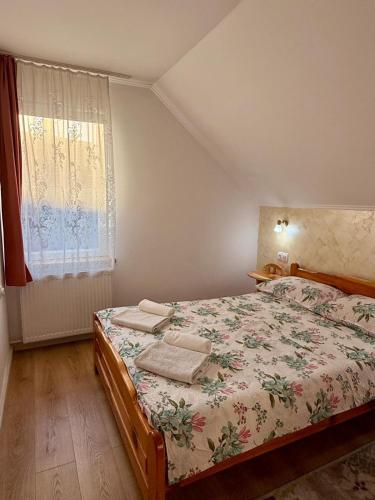 a small bedroom with a bed and a window at Bettina Apartman in Sovata