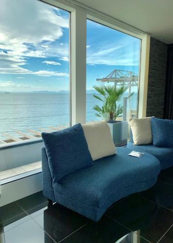 a blue couch sitting in front of a large window at NORTHSHOR Ehime 2F - Vacation STAY 12964 in Matsuyama