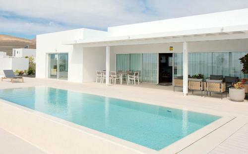 una villa con piscina y una casa en Villa Ainé Luxury Villa, en Puerto Calero
