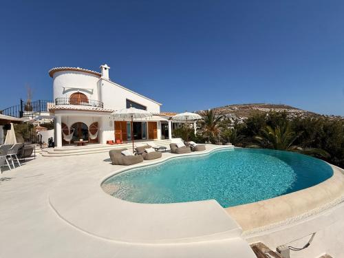 ein großes Schwimmbad vor einem Haus in der Unterkunft Zen House in Benitatxell