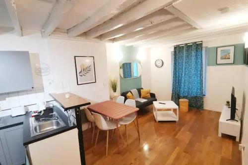 a kitchen and living room with a table and a couch at Charmant appartement au coeur de Château-Thierry in Château-Thierry