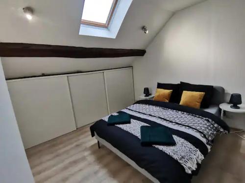 a bedroom with a large bed in a attic at Charmant appartement au coeur de Château-Thierry in Château-Thierry