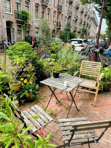 a picnic table and two chairs in a garden at Marijke's guestroom in Amsterdam