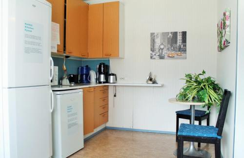 a kitchen with a white refrigerator and a table at Hotel Turistihovi in Kouvola