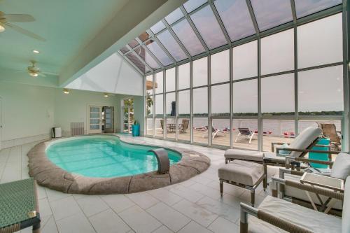 a large swimming pool in a large room with windows at Indoor Pool and Waterfront Deck Spacious Jay Home in Jay