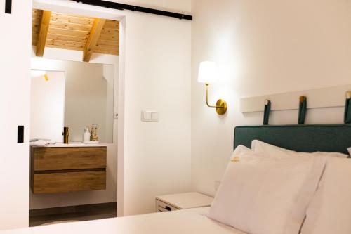 una camera da letto con un letto e un bagno con un lavandino di Casas do Freixial - Casa das Flores a Fundão