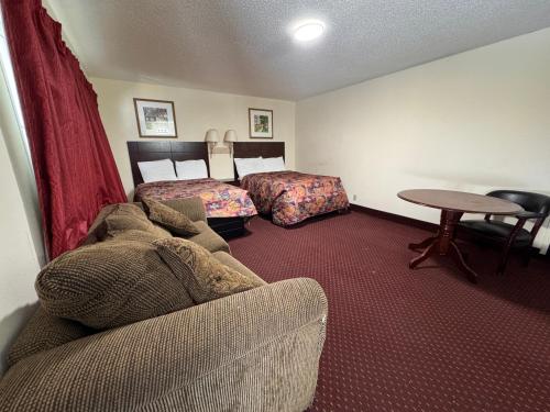 a hotel room with a couch and a bed and a table at Whispering Pines by Hotel O White stone VA in White Stone