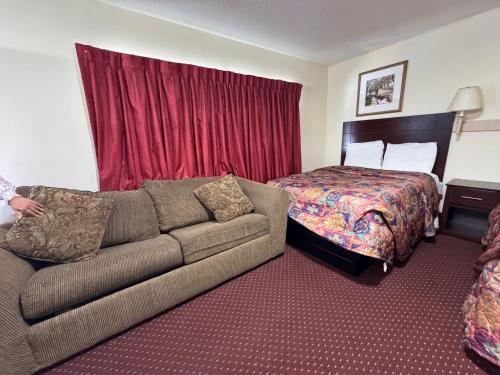 a hotel room with a couch and a bed at Whispering Pines by Hotel O White stone VA in White Stone