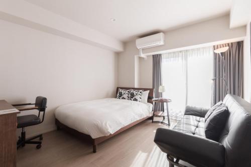 a bedroom with a bed and a couch at LANG HOTEL Kameido - Vacation STAY 79234v in Tokyo