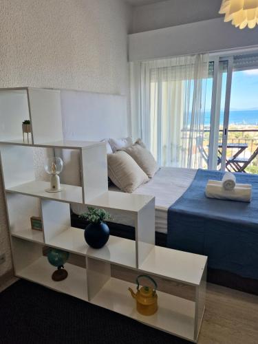 a living room with a bed and a large window at Sea view Cascais in Cascais