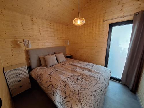 a bedroom with a bed in a room with a window at B&B Vierlingsbeek, Appartement en tuin-chalets in Vierlingsbeek