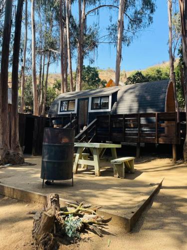 an rv with a picnic table and a trailer at Parque Laguna de Zapallar in Maitencillo