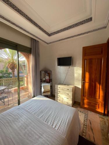 马拉喀什Ma kech house的一间带大床的卧室和一个阳台