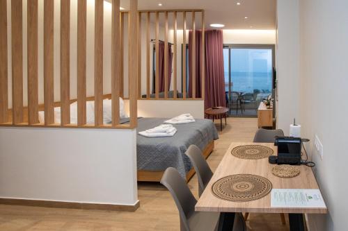 una camera d'albergo con letto e tavolo e una sala da pranzo di Enalis Studios & Apartments a Karfás