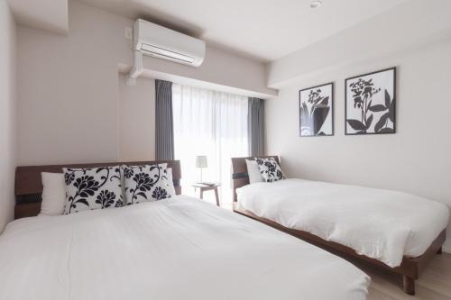 une chambre blanche avec deux lits et une fenêtre dans l'établissement LANG HOTEL Kameido - Vacation STAY 79460v, à Tokyo