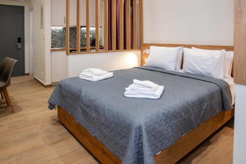 una camera da letto con un letto con asciugamani sopra di Enalis Studios & Apartments a Karfás