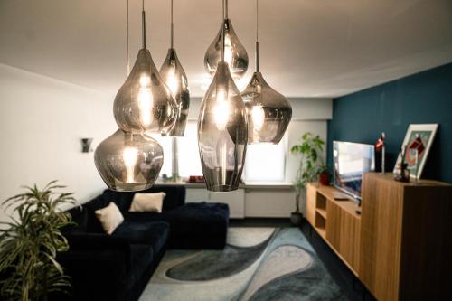 a living room with a couch and a tv at Appartement Central Luxembourg in Hesperange