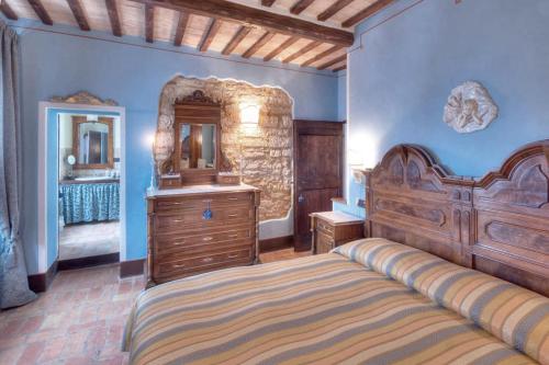 a bedroom with a bed and a dresser and a mirror at Country House Federico I in Sassoferrato