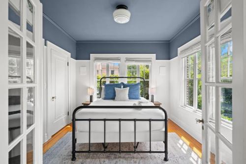 a bedroom with a bed with blue walls and windows at The Adaline #2 - Luxury Hyde Park Apt, Steps to Bayshore in Tampa