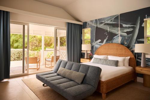 a bedroom with a bed and a couch and a patio at Sharon's Home in Harbour Island