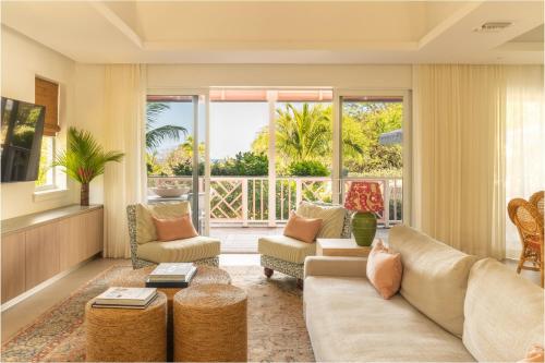 a living room with a couch and chairs and a large window at Brett's Home in Harbour Island