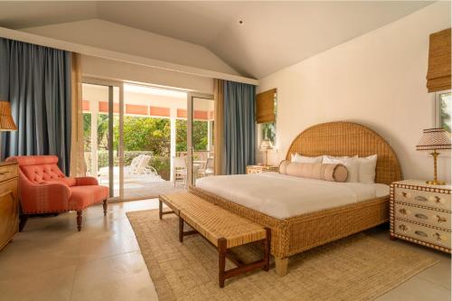 a bedroom with a large bed and a chair at Brett's Home in Harbour Island