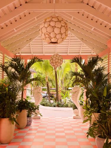 a hallway with palm trees and a chandelier at Brett's Home in Harbour Island