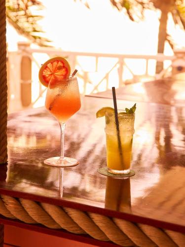 two cocktails sitting on top of a table at Brett's Home in Harbour Island
