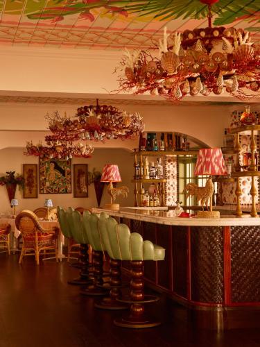 a bar with green chairs in a room at Brett's Home in Harbour Island