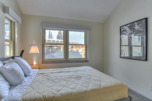 a bedroom with a bed and two windows at Wedgewood Lodge in Breckenridge
