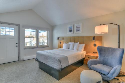 a bedroom with a bed and a blue chair at Wedgewood Lodge in Breckenridge