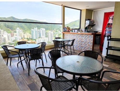 restauracja ze stołami i krzesłami oraz dużym oknem w obiekcie Apartamento con piscina en el rodadero Eificio VITA w mieście Rodadero