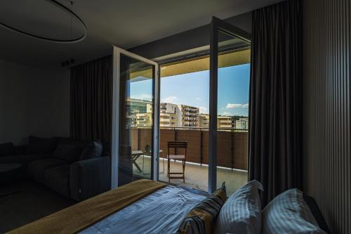 a bedroom with a bed and a large glass window at CH Apartments Urban Plaza in Braşov