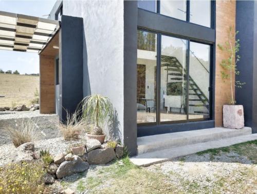 a house with large windows and a staircase at Hermoso y cómodo Loft Campestre in Omitlán de Juárez