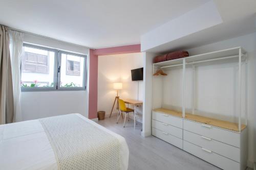 a bedroom with a bed and a desk and a window at Banana Garden La Palma in Santa Cruz de la Palma