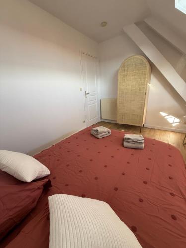 una camera da letto con un grande letto rosso in mansarda di Nid douillet avec parking a Vierzon