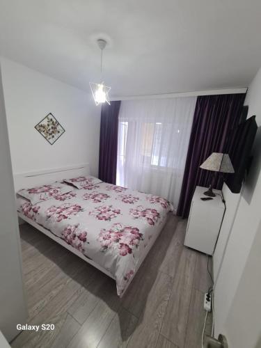 - une chambre avec un lit et une lampe sur du parquet dans l'établissement Apartament Central Slanic-Moldova, à Slănic-Moldova