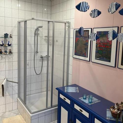 a bathroom with a shower and a blue counter at Harz und Gemütlich in Blankenburg