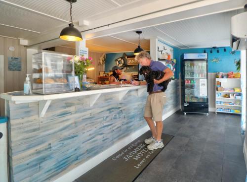 a man standing at the counter of a restaurant at The Janmere Motel in Hampton