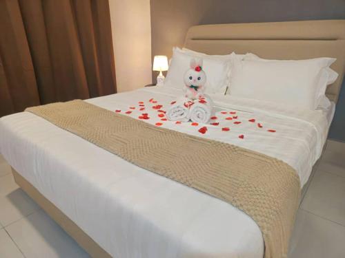 a white bed with a teddy bear sitting on it at Pangsapuri Medini 1 And Meridian 2 - Iskandar Puteri in Iskandar Puteri