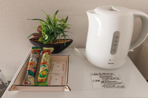 a table with a white vase and a box and a plant at LANG HOTEL Kameido - Vacation STAY 76836v in Tokyo
