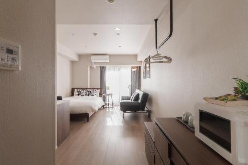 a bedroom with a bed and a living room at LANG HOTEL Kameido - Vacation STAY 76836v in Tokyo