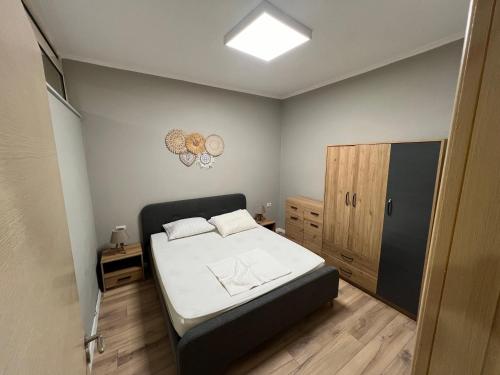 ein kleines Schlafzimmer mit einem Bett und einem Schrank in der Unterkunft APT Sherko in Sarandë