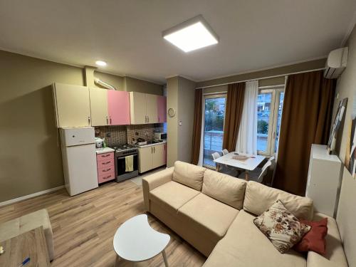 ein Wohnzimmer mit Sofa und eine Küche in der Unterkunft APT Sherko in Sarandë