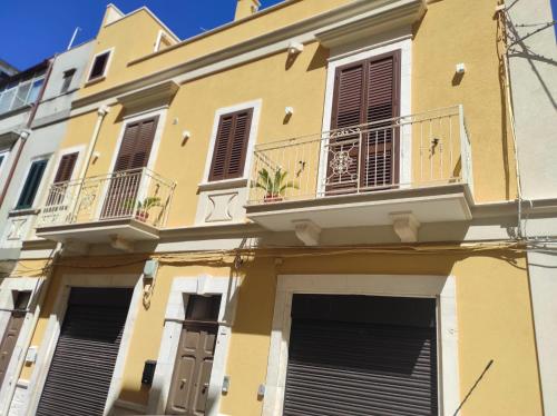 a yellow building with windows and balconies at Elena 's HOME in Conversano