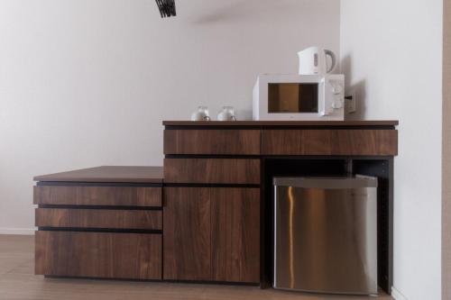 a microwave oven sitting on top of a wooden cabinet at LANG HOTEL Kameido - Vacation STAY 76954v in Tokyo