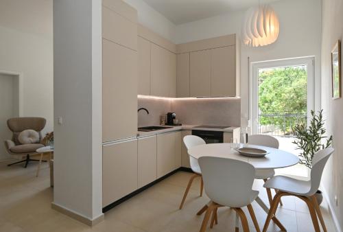 a kitchen with white cabinets and a table and chairs at Casa Dalmacija in Krvavica