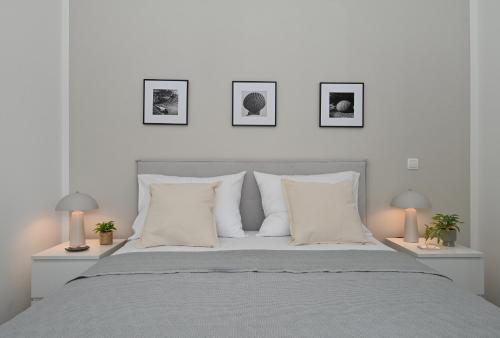 a white bedroom with a large bed with two lamps at Casa Dalmacija in Krvavica
