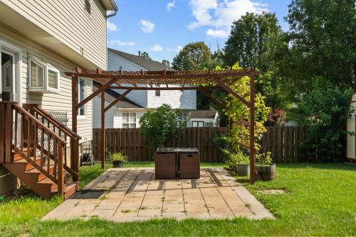 a pergola in a yard next to a house at Family friendly single house Close to Washington DC in Woodbridge