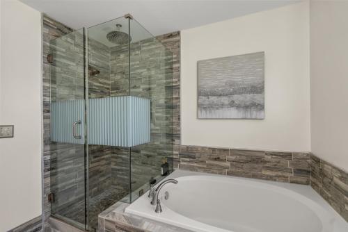 a bathroom with a tub and a glass shower at Family friendly single house Close to Washington DC in Woodbridge